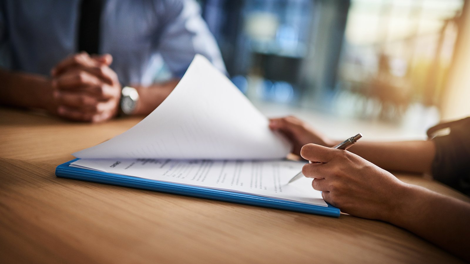 Cropped shot of a man and woman completing paperwork together at a desk